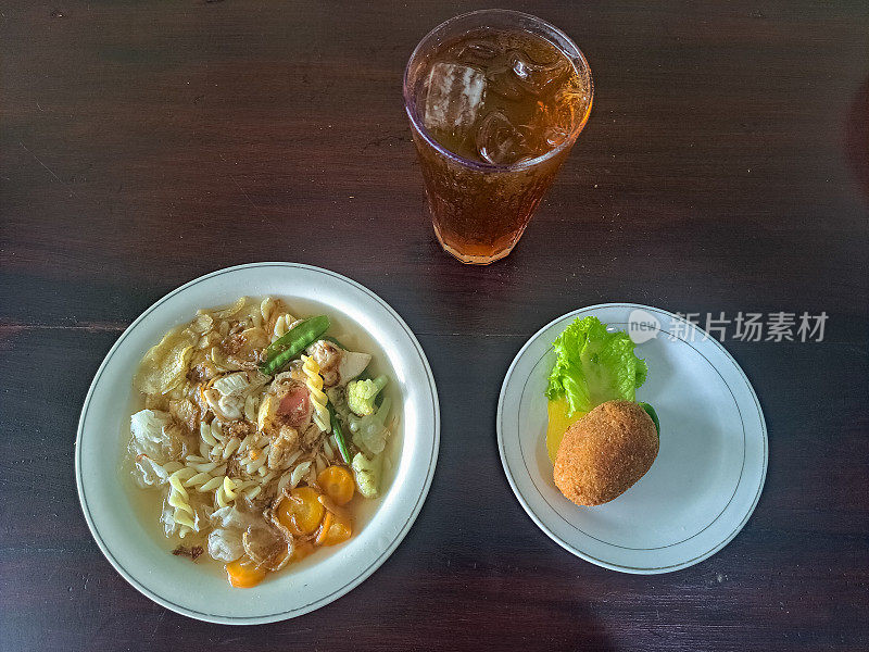 印尼的婚礼汤。配雪豆，胡萝卜，意大利面，雪蘑菇，西兰花，炸洋葱，薯片和鸡肉。马铃薯丸子(Kentang Kroket)。冰鲜茶(Es Teh Segar)食物和饮料菜单。前视图。